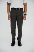 Person wearing gray pants and black shoes on a white background