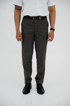Person wearing gray pants and black shoes on a white background