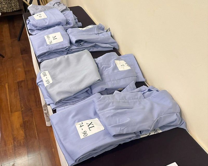 Folded blue shirts on a table with size labels